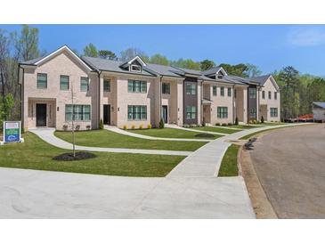 Beautiful townhome exterior featuring a well-manicured lawn and inviting entrances at 173 Brush Creek Ct, Stockbridge, GA 30281