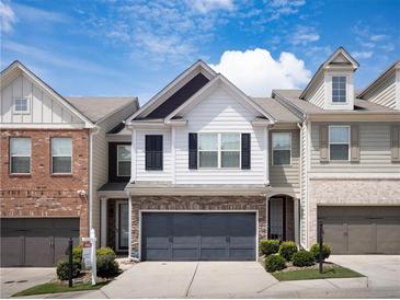 Charming two-story home with a two car garage, white siding, and well-maintained landscaping at 5715 Radford Loop # 15, Fairburn, GA 30213