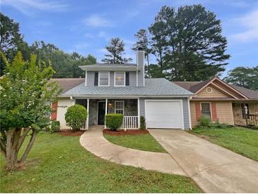 Charming home with a well-maintained front yard and a driveway leading to an attached garage at 8332 Mountain Pass, Riverdale, GA 30274