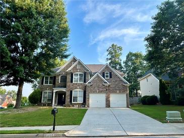 Charming two-story brick home with a well-manicured lawn and attached two-car garage at 1055 Havenstone Walk, Lawrenceville, GA 30045