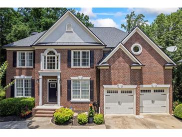 Charming brick home featuring a well-manicured lawn and a two-car garage at 1547 Grove Arbor Ter, Dacula, GA 30519