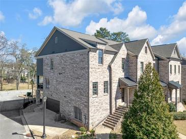 Beautiful brick townhome featuring a two-car garage, a gabled roof, and a manicured lawn at 2850 Stonehall Se Ct, Smyrna, GA 30080