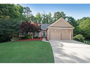 Charming single-story home boasts a manicured lawn, two-car garage, and inviting entrance with lush landscaping at 450 Hunt Creek Dr, Acworth, GA 30101