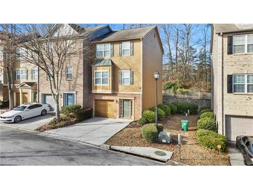 Charming two-story townhome with neutral siding, attached garage, and well-manicured landscaping at 2793 Keystone Ave, Lithonia, GA 30058