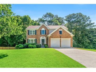 Beautiful two-story brick home with a well-manicured lawn and a two-car garage at 7505 Brookwood Way, Cumming, GA 30041