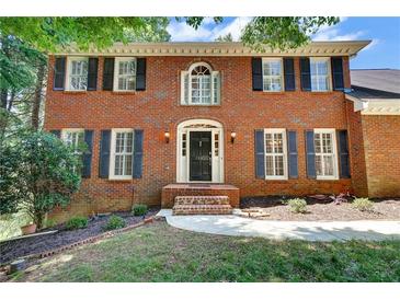 Charming brick two-story home with symmetrical design and a well-manicured front yard at 2935 Abbottswell Dr, Alpharetta, GA 30022