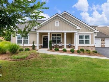 Charming home with a covered porch, manicured lawn, and well-maintained landscaping at 1802 Lexington Green Pnes, Cumming, GA 30040