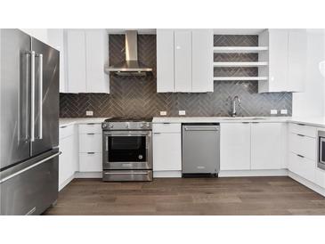 Modern kitchen featuring stainless steel appliances, white cabinetry, and stylish herringbone backsplash at 788 W Marietta Nw St # 1404, Atlanta, GA 30318