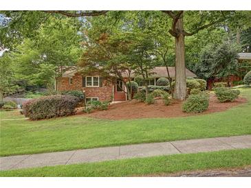 Charming brick home with a beautifully landscaped front yard and mature trees at 1693 Alderbrook Ne Rd, Atlanta, GA 30345