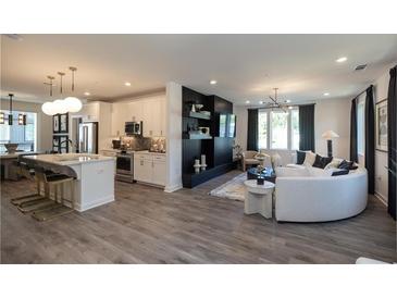 Open-concept living room features modern decor, wood floors, and an elegant black media center at 371 Grant Cir # 1812, Atlanta, GA 30315