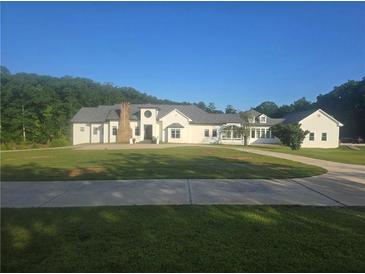 Beautiful, spacious white home with a large front yard and a winding driveway at 1169 Hodges Cir, Mansfield, GA 30055