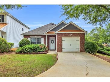 Charming single-story brick home with a well-manicured lawn and attached one-car garage at 401 Buckboard Ln, Locust Grove, GA 30248