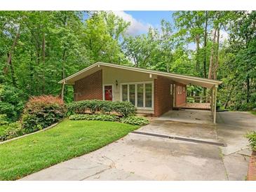 Charming brick home with a well-manicured lawn, lush landscaping, and attached covered parking at 1103 Lee Ne Cir, Atlanta, GA 30324