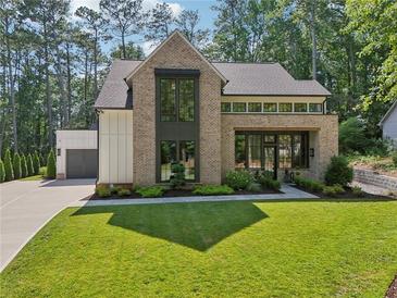 Stunning brick home with modern windows, well-manicured lawn and an attached two car garage at 477 Michael Dr, Alpharetta, GA 30009