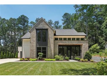 Stunning two-story brick home with a manicured lawn and contemporary design details at 477 Michael Dr, Alpharetta, GA 30009