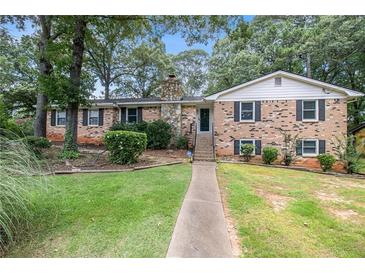 Charming brick home with a stone chimney and lush green lawn at 60 Ivy Dr, Covington, GA 30016