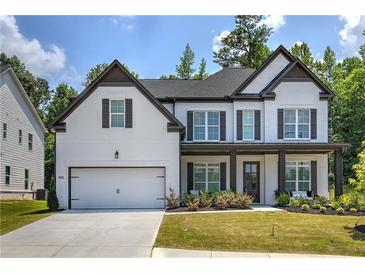 Charming two-story home featuring white brick, dark accents, a two-car garage, and a welcoming front porch at 841 Keystone Dr, Woodstock, GA 30188