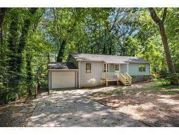 Charming single-story home with a welcoming front porch and driveway at 303 Nottingham Dr, Woodstock, GA 30188