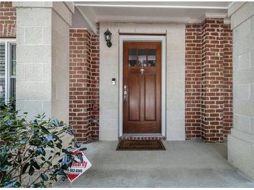 Charming brick-accented entryway with a wood front door and welcoming welcome mat at 1836 Preserve Way, Brookhaven, GA 30341