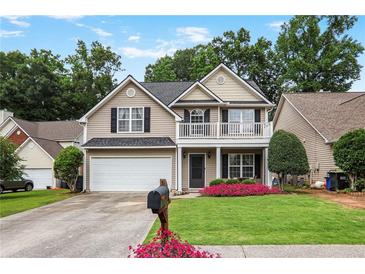 Charming two-story home with a front porch and a well-manicured lawn with a flower bed at 306 Overbend Sw Lndg, Marietta, GA 30008
