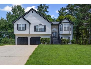 Charming two-story home featuring a two-car garage, manicured lawn and a traditional design at 397 Lovejoy Cir, Powder Springs, GA 30127