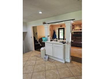 Inviting living room features tile floors, columns, and access to backyard at 616 Burnt Creek Nw Way, Lilburn, GA 30047