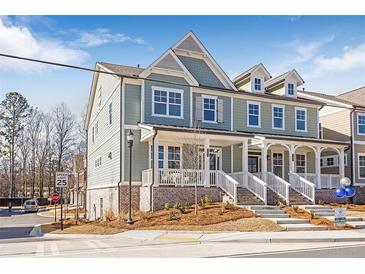 Charming two-story home with covered porch, landscaped yard and blue and grey siding at 164 Palm St, Holly Springs, GA 30188