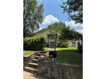 Charming single-story home with mature trees and front yard fenced-in with black iron at 661 Federal Se Ter, Atlanta, GA 30315