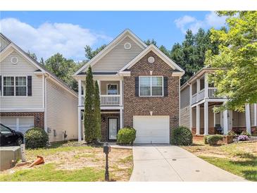 Charming two-story home with brick facade, second-story balcony, and attached one-car garage at 6341 Lake Valley Pt, Lithonia, GA 30058