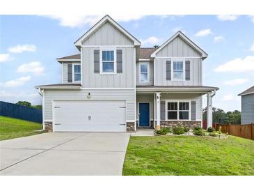 Charming two-story home featuring a two-car garage, light gray siding, dark shutters, and a bright blue front door at 230 Waters Edge Pkwy, Temple, GA 30179