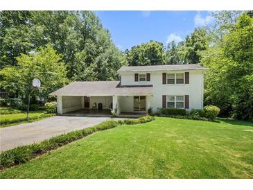 Charming two-story home features a brick exterior, a basketball hoop, and a large, well-manicured front lawn at 4389 Hambrick Way, Stone Mountain, GA 30083