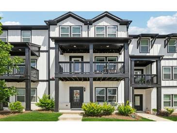 Charming townhome with a covered porch and classic black-and-white trim offers inviting curb appeal at 1104 Knoxboro Ln, Woodstock, GA 30188