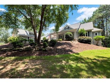 Inviting gray two-story home featuring manicured lawn, mature trees, and tasteful landscaping at 4882 Rabbit Farm Road Rd, Loganville, GA 30052