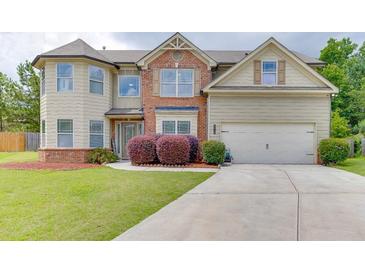 Charming two-story home featuring a manicured lawn, brick accents, and an attached two-car garage at 1548 Station Ridge Dr, Lawrenceville, GA 30045