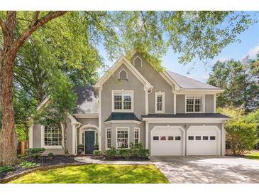 Charming two-story home with gray stucco exterior, well-manicured landscaping, and a two-car garage at 908 Lance Cir, Lawrenceville, GA 30043