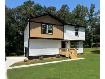 Charming two-story home with a combination of tan and white siding and a well-maintained lawn at 110 Wildwood Dr, Stockbridge, GA 30281