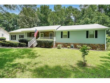 Charming single-story home with a stone accent, well-manicured lawn, and inviting front porch at 180 Kim Trail Trl, Stockbridge, GA 30281