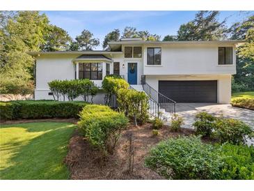 Beautifully landscaped two-story home features a lush lawn, charming shrubbery, and a blue front door at 2010 Barnes Mill Rd, Marietta, GA 30062