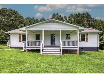 Charming home featuring a covered porch with stylish railings and lush green lawn at 2122 Browntown Rd, Rockmart, GA 30153