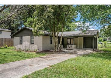Charming painted brick home with dark trim, mature trees, and a long driveway at 5400 Louis Xiv Ln, Atlanta, GA 30349