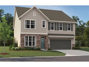Charming two-story home with stone accents, gray siding, a two-car garage, and a well-manicured lawn at 7216 Eton Ln, Locust Grove, GA 30248
