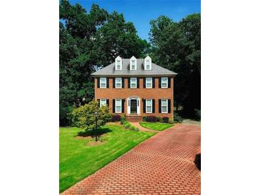 Charming two-story brick home with black shutters, dormer windows, manicured lawn, and brick driveway at 3201 Palisades Se Ct, Marietta, GA 30067