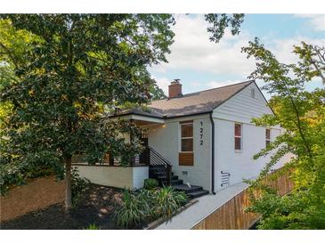 Charming white brick home featuring a covered porch, landscaped yard, and modern architectural details at 1272 Hardee Ne St, Atlanta, GA 30307