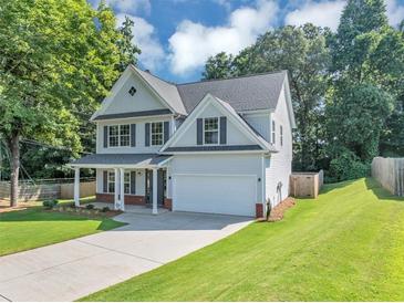 Charming two-story home with a well-manicured lawn, covered porch, and attached two-car garage at 5195 Oaks Landing Ct, Sugar Hill, GA 30518