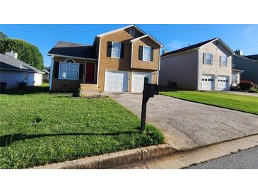Charming two-story home featuring a manicured lawn and two-car garage at 842 Shoals Ct, Atlanta, GA 30349