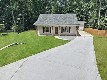Charming single-story home featuring a new driveway, front porch, and a well-manicured lawn at 1337 Fairfield Dr, Lilburn, GA 30047
