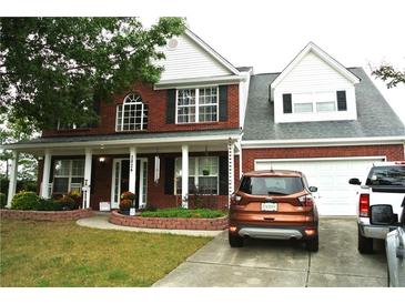 Charming two-story brick home with well-maintained landscaping and inviting front porch at 3824 Smith Creek Ct, Buford, GA 30519