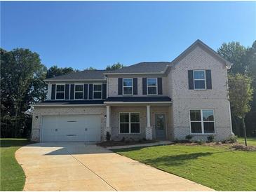 Charming two-story home featuring a two-car garage, light brick facade, and a well-manicured front lawn at 5305 Birch Valley Rd, Cumming, GA 30028