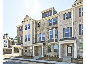 Modern townhome showcases a brick facade, large windows, and covered front entry at 541 Fundao Ln, Lawrenceville, GA 30046