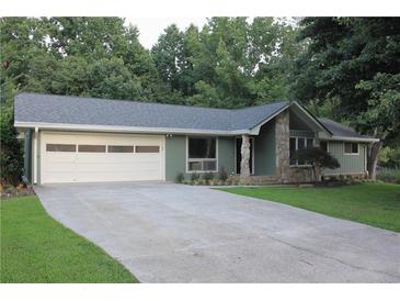 Charming home showcasing stone accents, a gray roof, a spacious two-car garage, and a well-manicured lawn at 6878 Vic Ar Rd, Atlanta, GA 30360